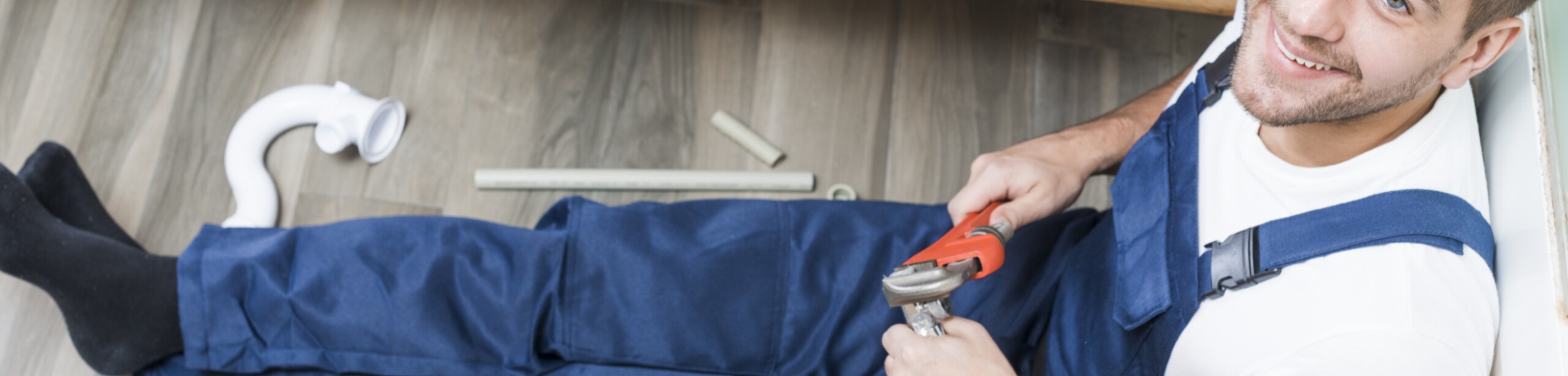 cheerful-adult-plumber-sitting-in-bathroom